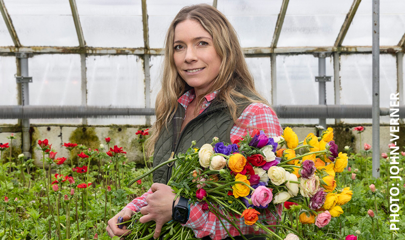 Morgan Battenfeld with bouquet of fresh cut flowers in greenhouse